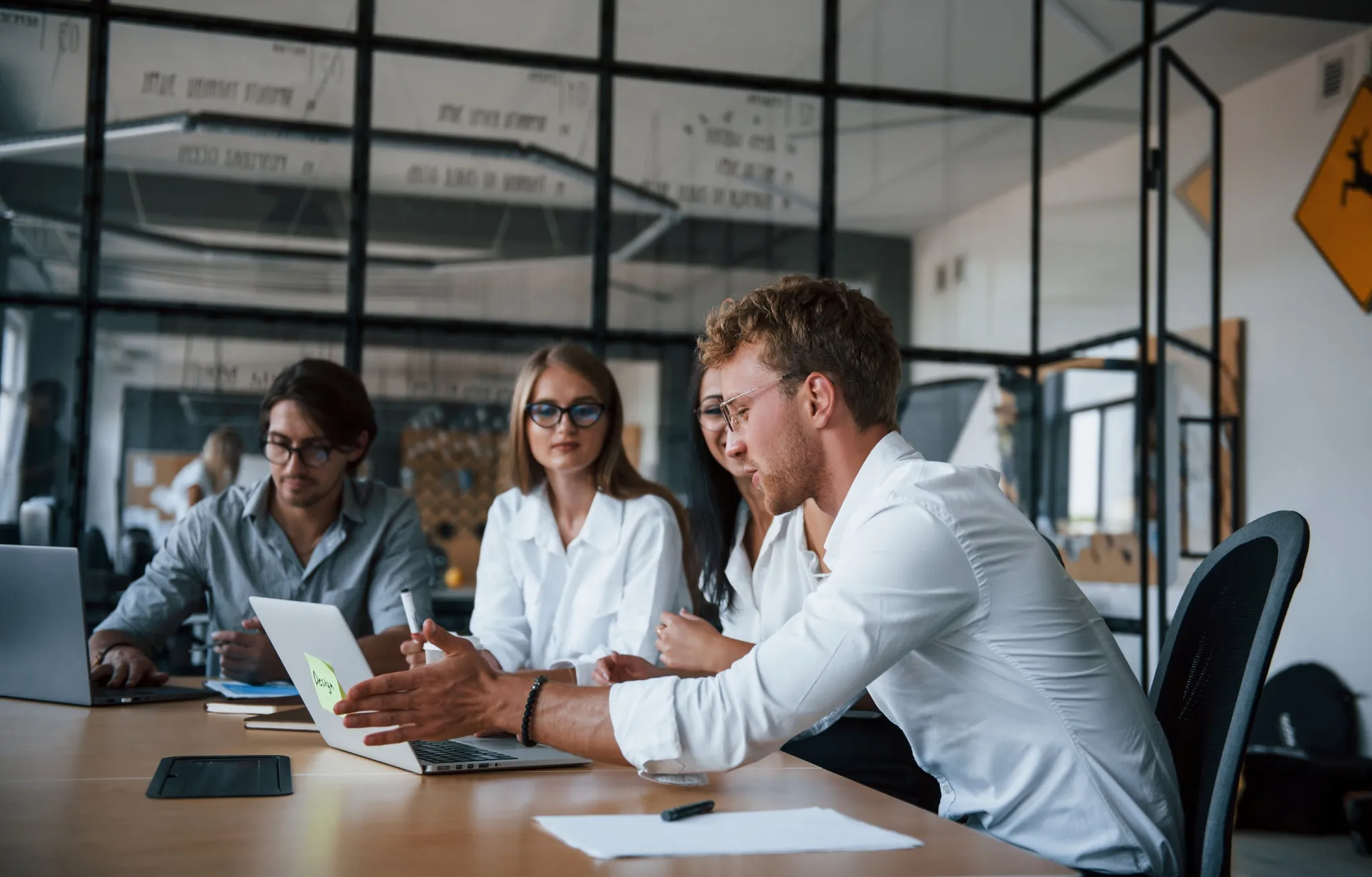 Réunion d’équipe pour un projet d’achat de bureaux autour d’une table dans un bureau moderne en verre